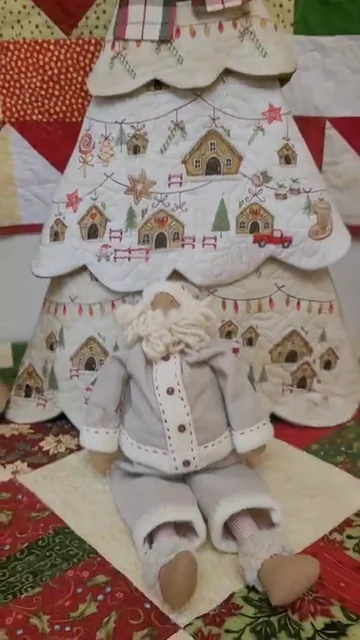 Árvore de Natal de tecido estampado, com um boneco de tecido à frente.