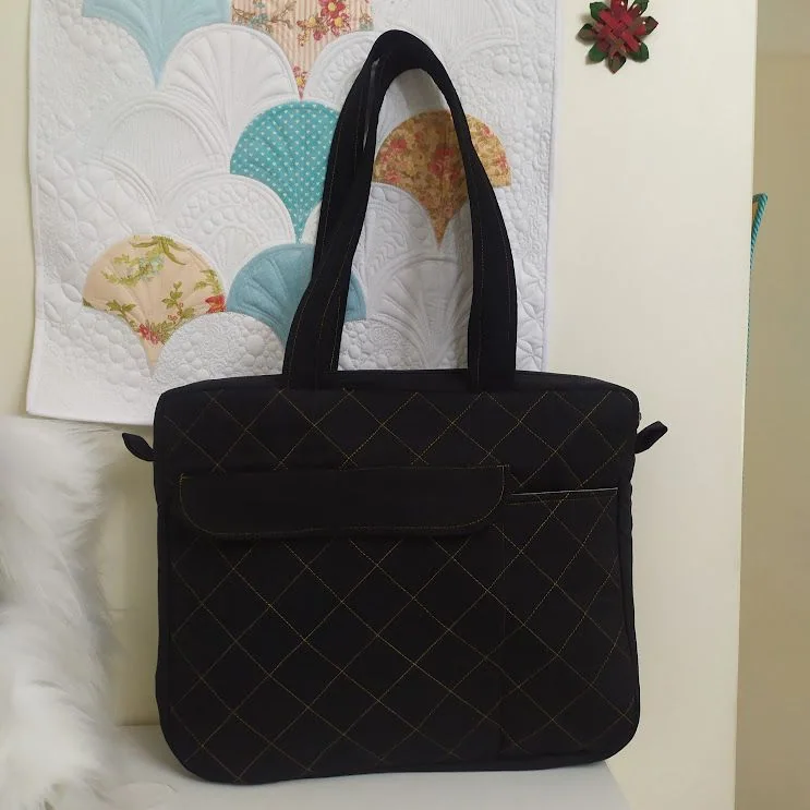 Bolsa preta de alças curtas com quilting em losangos.