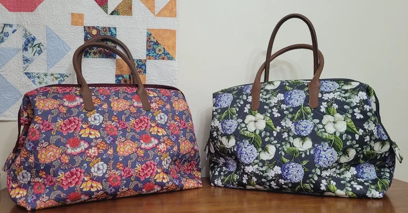 Duas bolsas de alças estruturadas, com estampas florais coloridas.