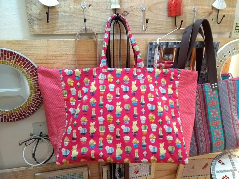 Bolsa rosa com estampa de pequenas bonecas.