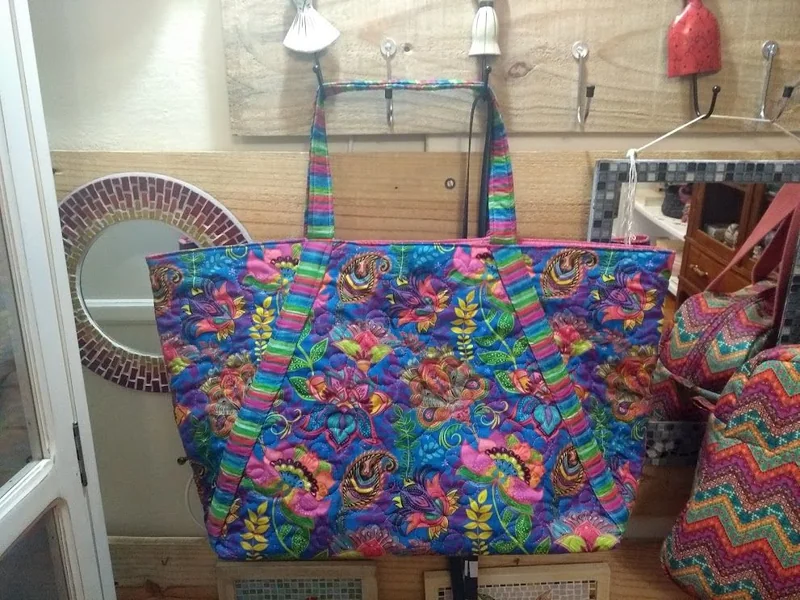 Bolsa de ombro de tecido floral colorido.