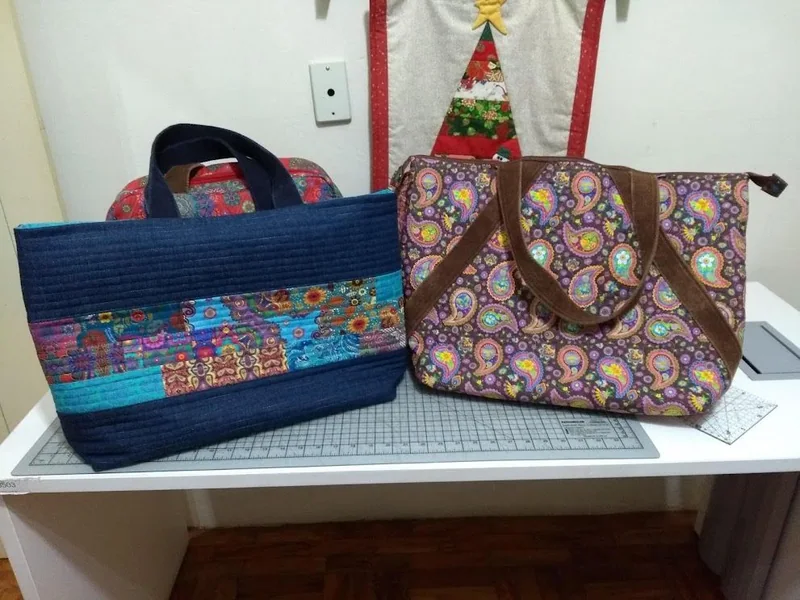 Bolsa de estampa circular ao lado de uma bolsa azul de retalhos.