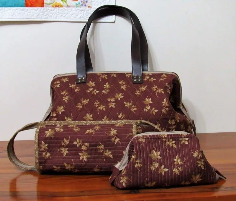 Bolsa e nécessaire marrons com desenhos de quilting e pequenas flores.
