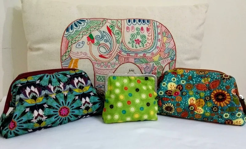 Três bolsinhas com estampas florais e geométricas.