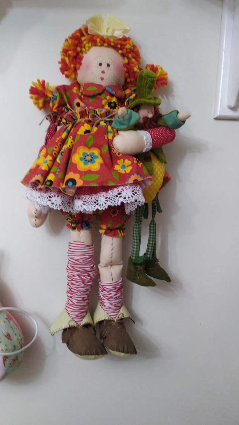 A mesma boneca caipira vista de frente, com a saia de babados e os sapatos marrons.