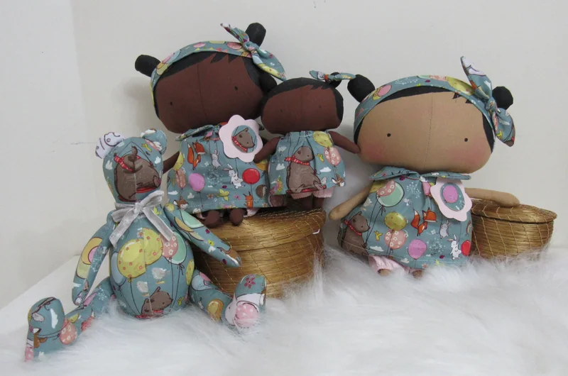 Três bonecas e um urso feitos com tecidos de estampas coordenadas.