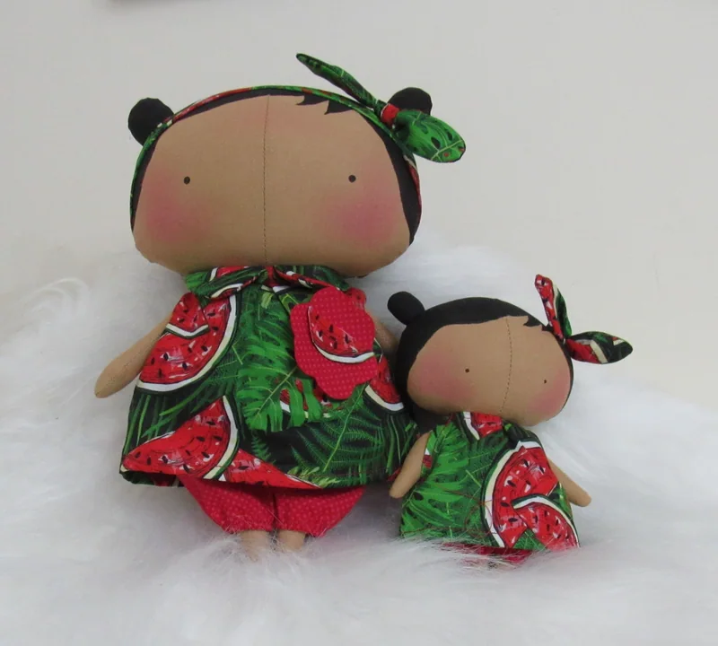 Duas bonecas de tamanhos diferentes, com vestidos estampados de melancia.