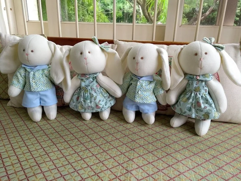 Coelhos com roupas coordenadas em azul e verde.