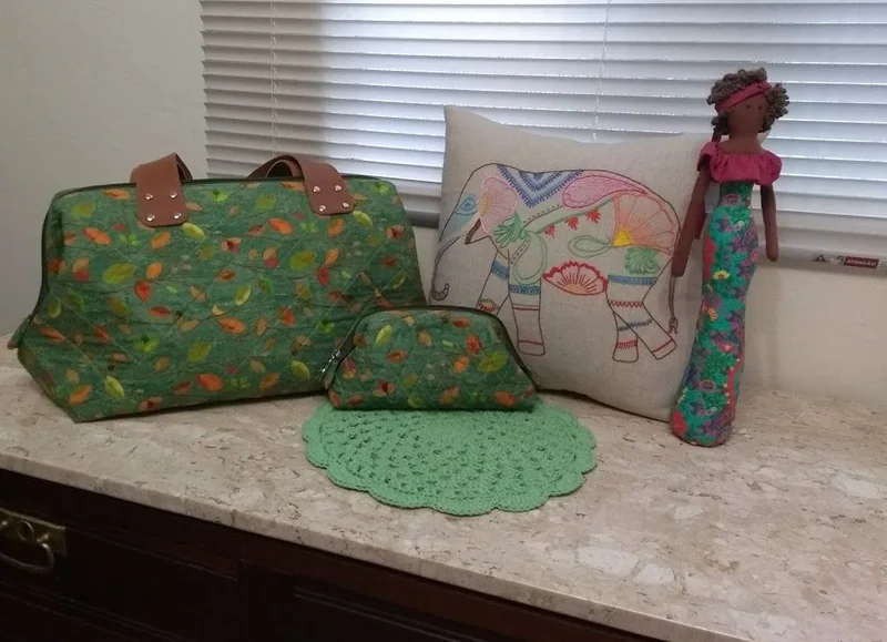 Bolsa e nécessaire em tecido floral verde.