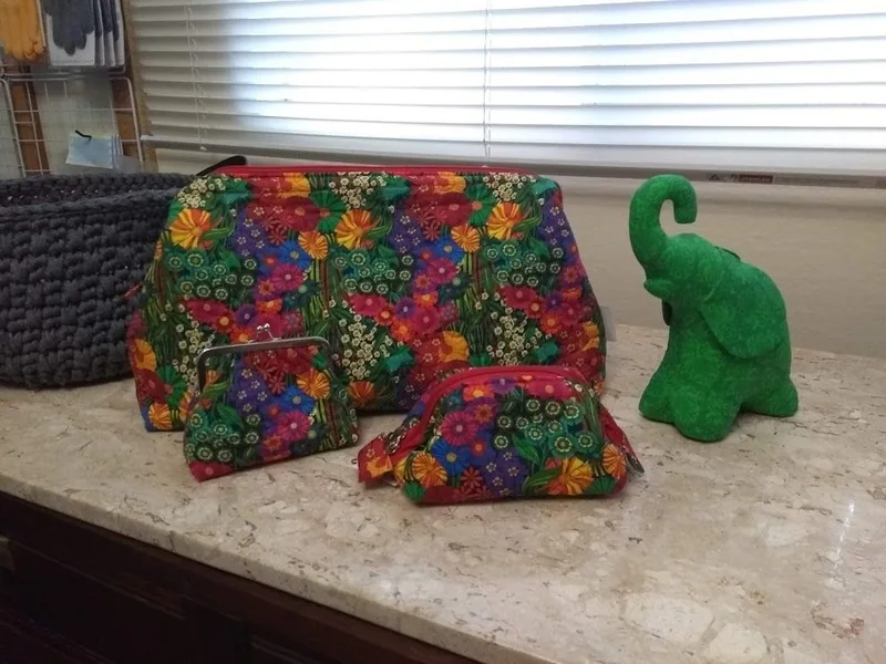 Conjunto de bolsas em fundo escuro com flores coloridas.
