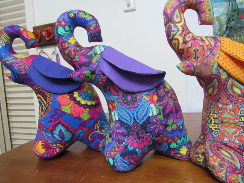 Detalhe de um elefante floral com orelhas roxas.
