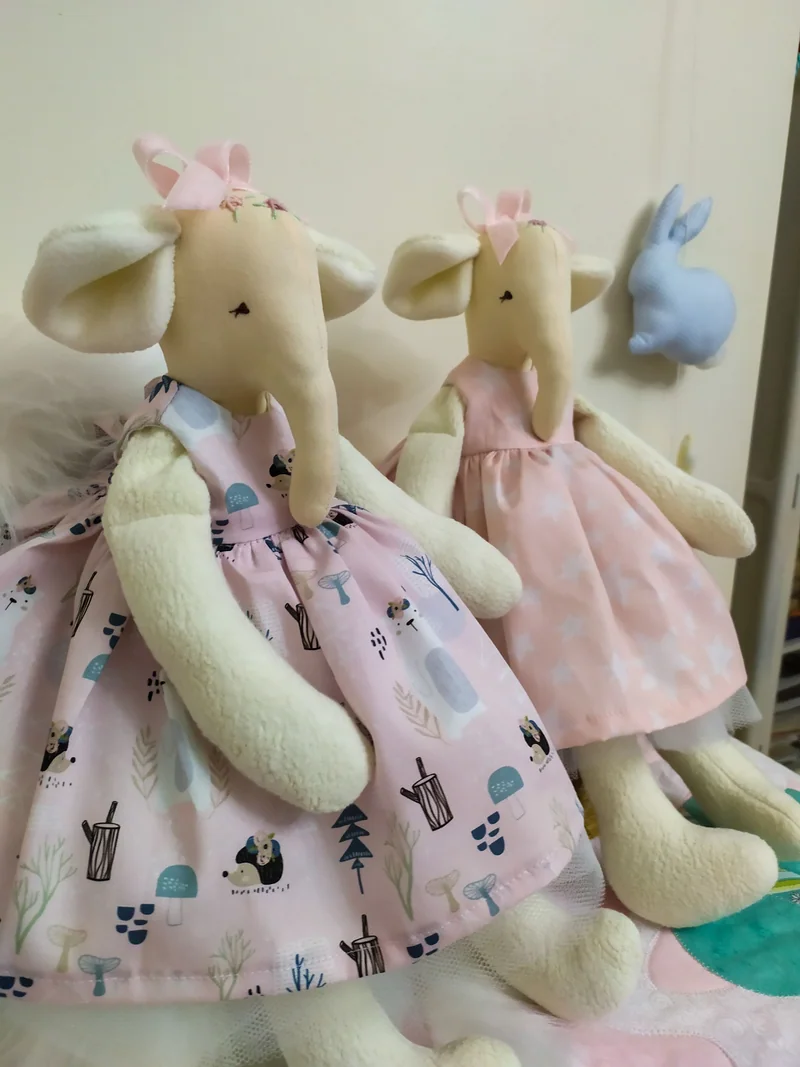 Duas elefantinhas de tecido com vestidos rosa, um liso e outro estampado.