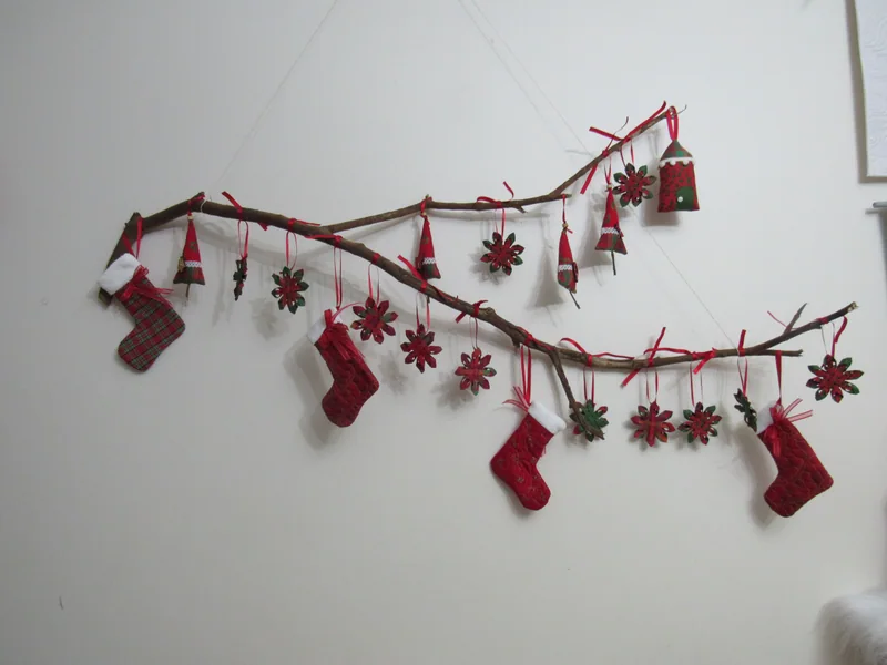Galhos com meias, estrelas e pequenos enfeites de Natal em vermelho e branco.