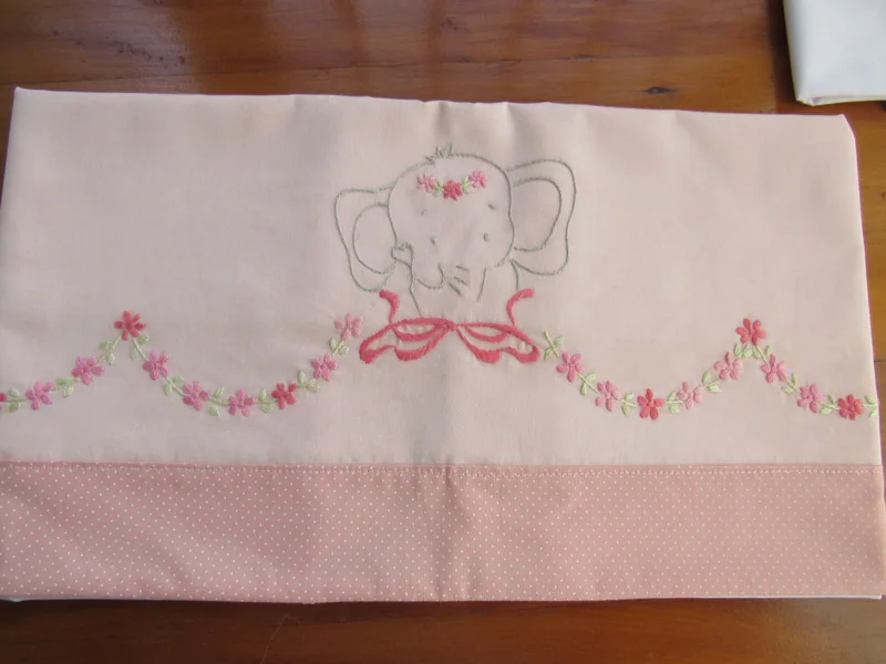 Detalhe do elefantinho e das flores bordadas em rosa.