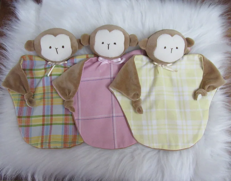 Três naninhas de macaquinho com corpos de tecido xadrez.