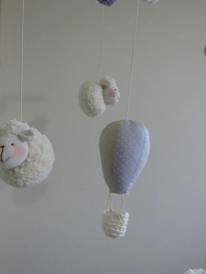 Detalhe do balão lilás e das pequenas ovelhas de tecido suspensas.