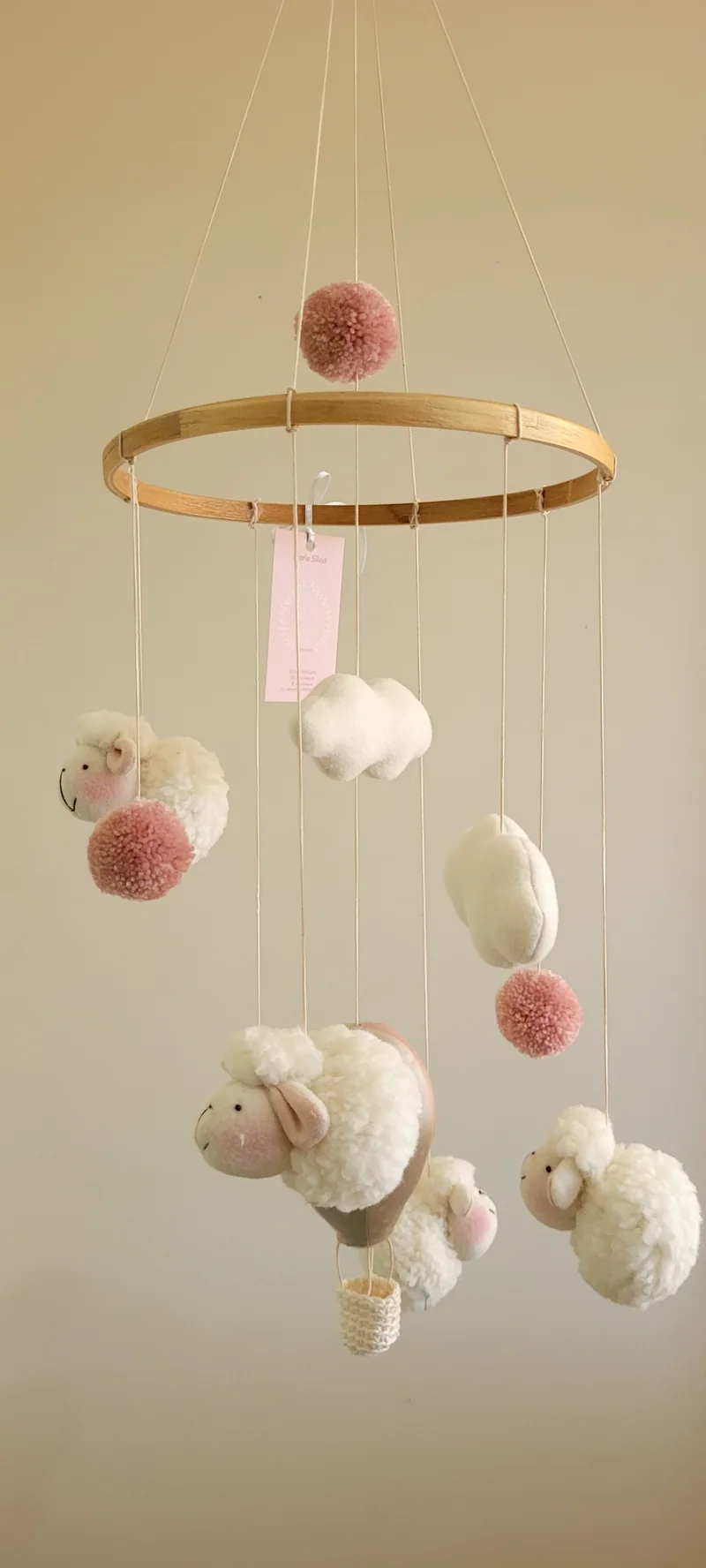 Outro móbile do mesmo modelo, com ovelhinhas, nuvens, balão e pompons rosa.