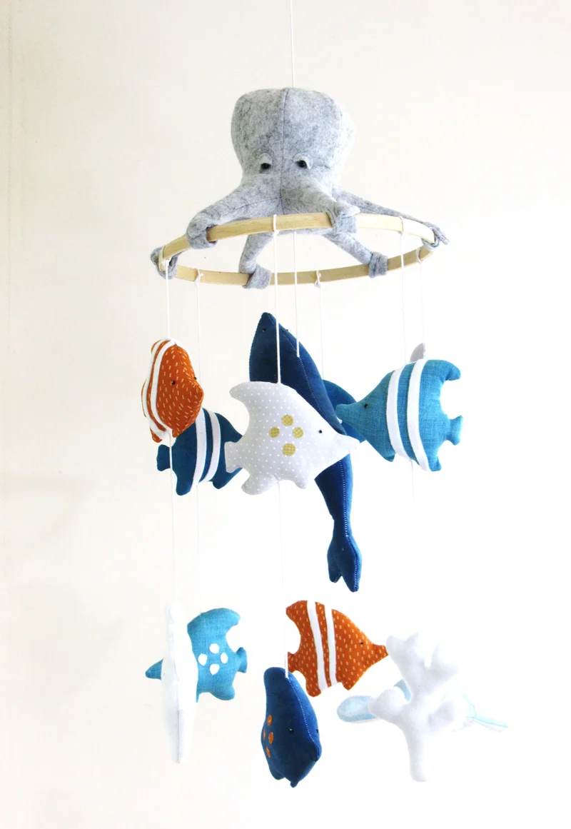 Móbile com animais marinhos de tecido em azul, branco e laranja.