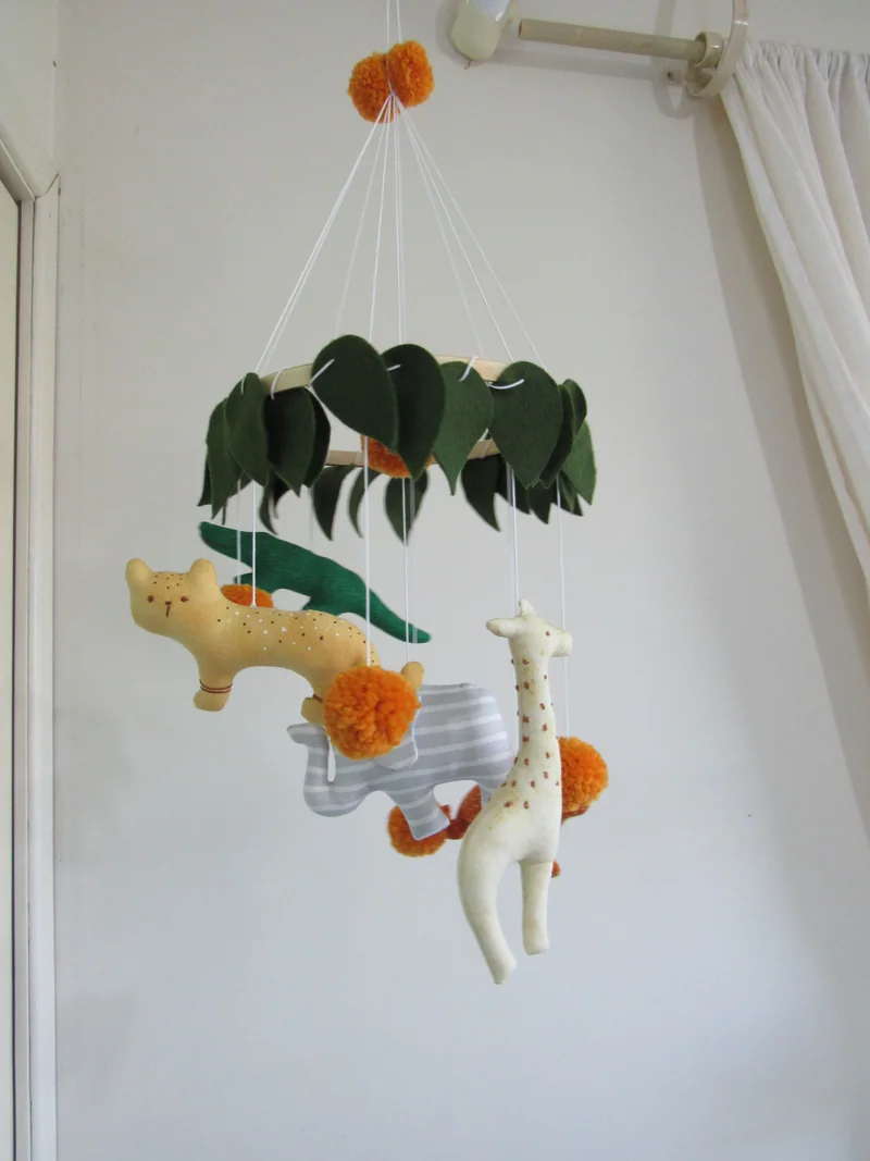 Outra vista dos animais e das folhas do móbile de safári.