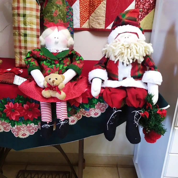 Papai e Mamãe Noel sentados, com roupas vermelhas e verdes.