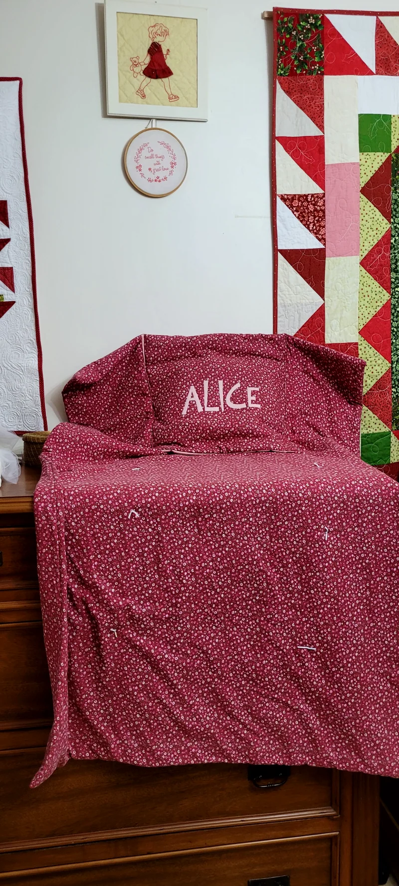 Manta vinho aberta sobre a cadeira, com o nome Alice bordado.