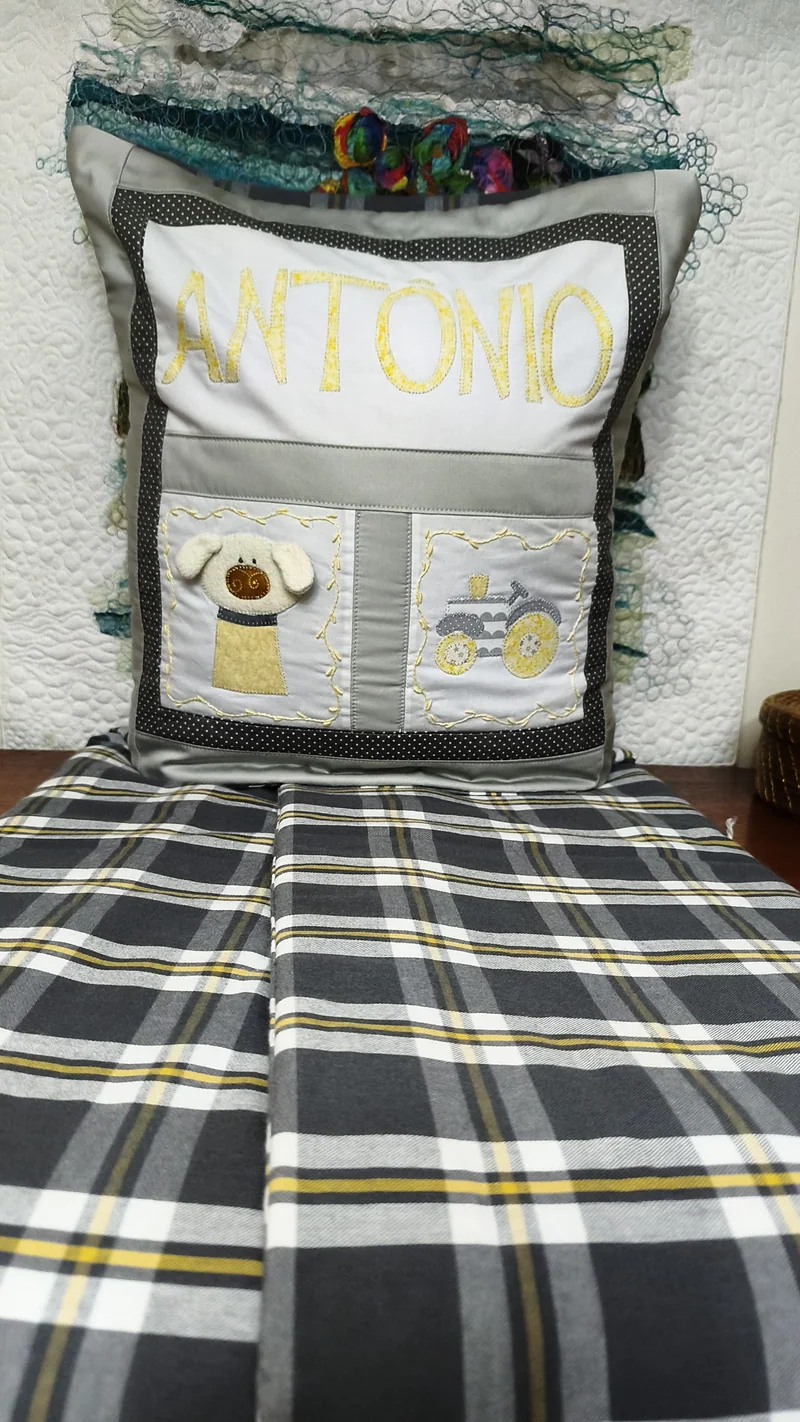 A mesma almofada com a manta xadrez preta e amarela aberta.