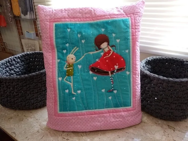 Quillow rosa com uma bailarina sobre fundo azul.