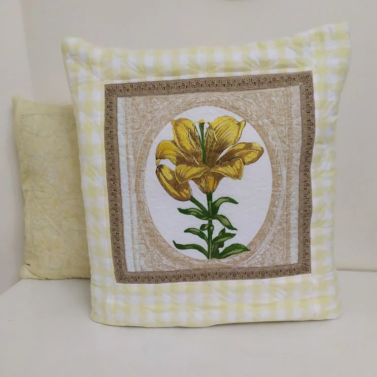 Quillow claro com uma flor amarela e bordas xadrez.