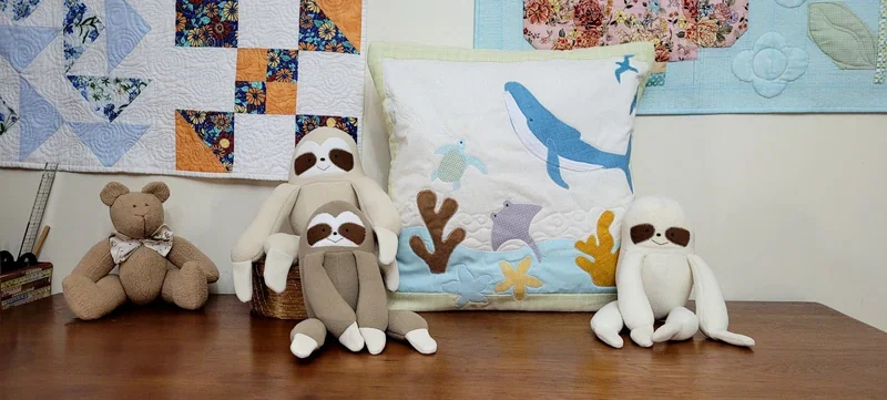 Quillow com animais marinhos azuis e coloridos, entre bichinhos de tecido.
