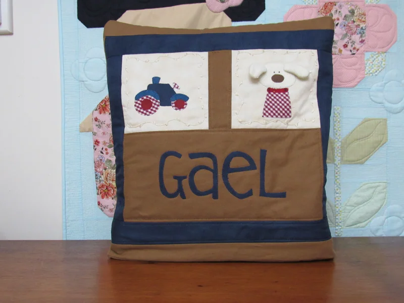 Quillow com o nome Gael, aplicações de cachorro e trator e bordas azuis.