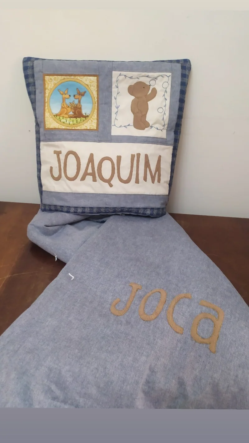 Quillow com o nome Joaquim, dois painéis de tecido e a manta cinza aberta.