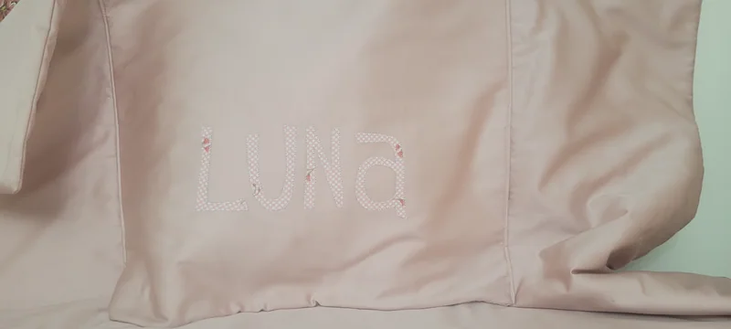 Manta bege com o nome Luna bordado tom sobre tom.