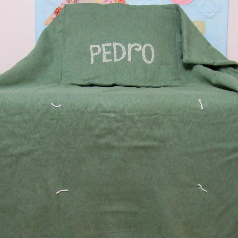 Manta verde com o nome Pedro bordado.